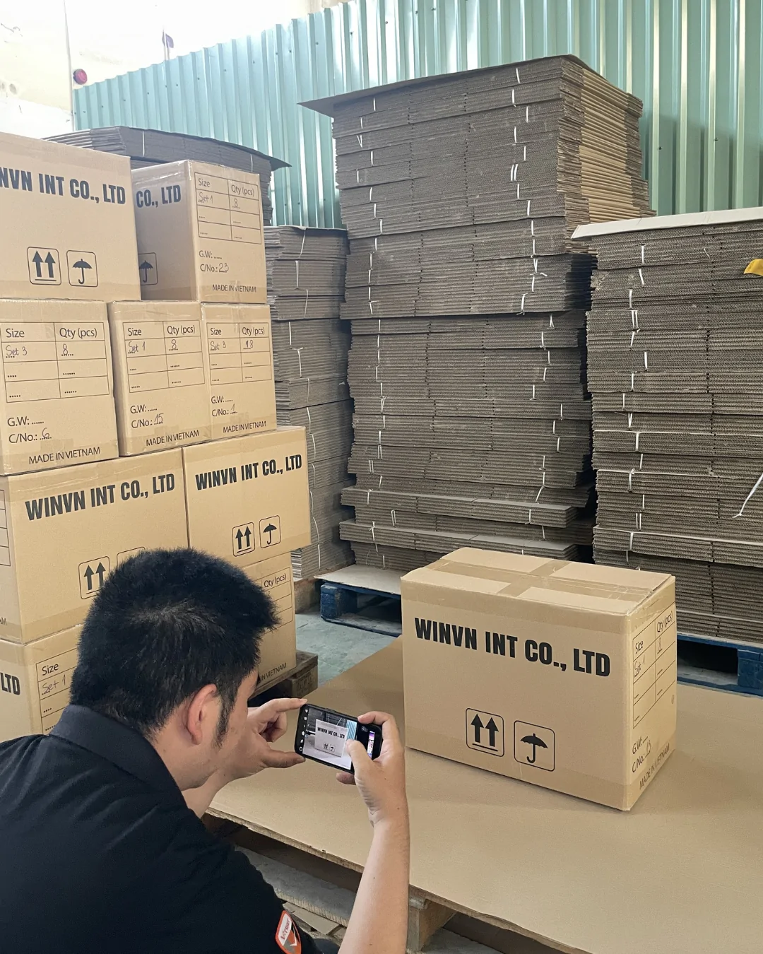 A WINVN INT staff member photographing a sealed master carton for the shipping file