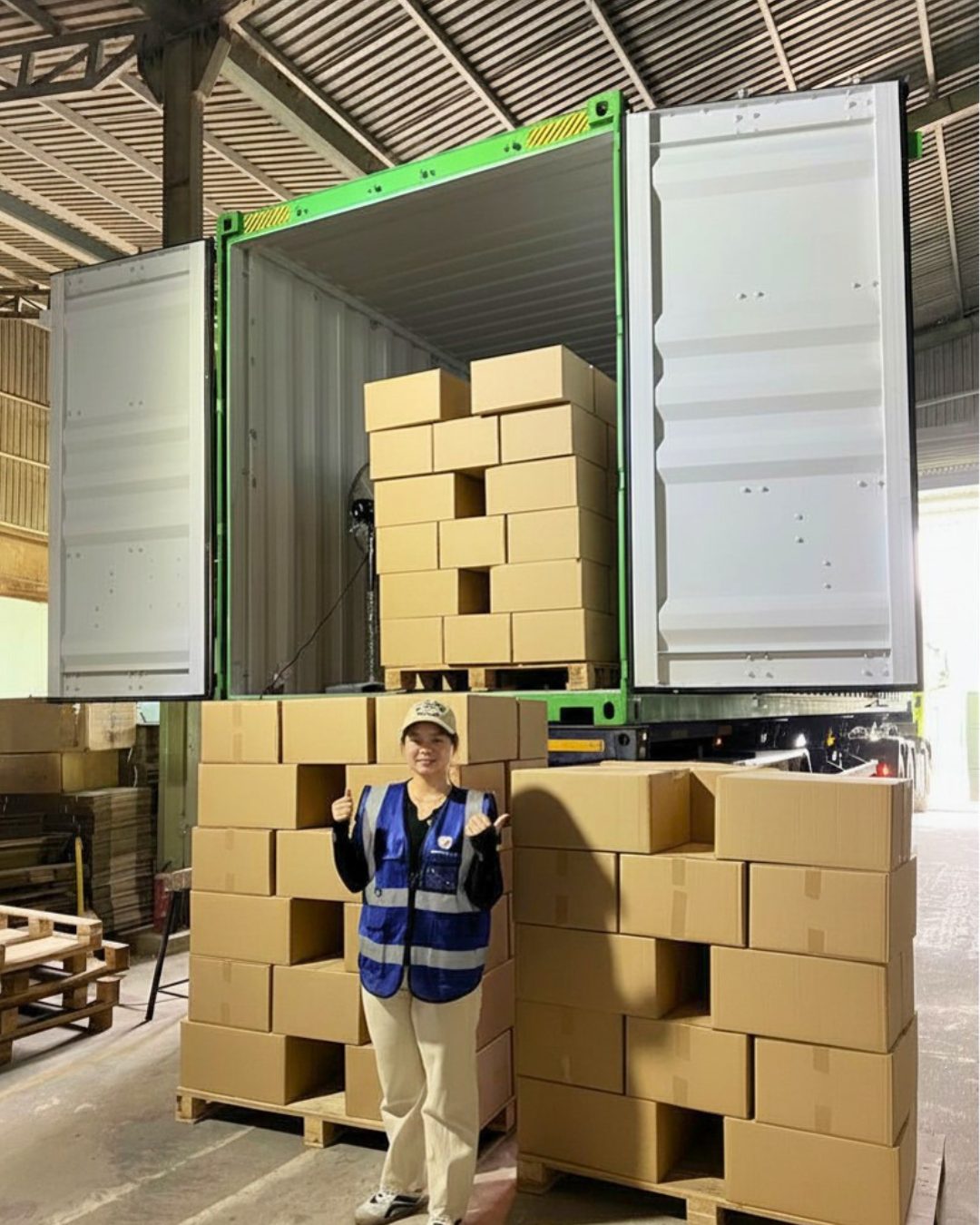 Pallets of export cartons staged at the open doors of a shipping container ready for stuffing