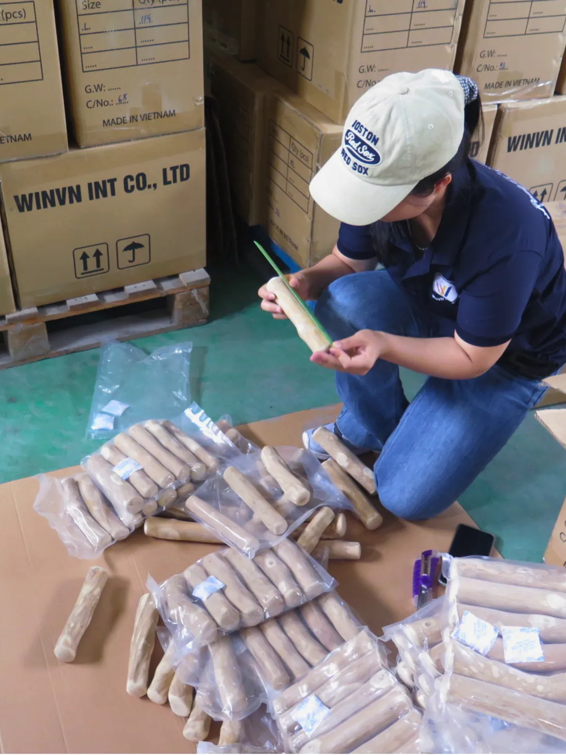 A WINVN INT quality inspector counting and grading coffee wood chews before packing